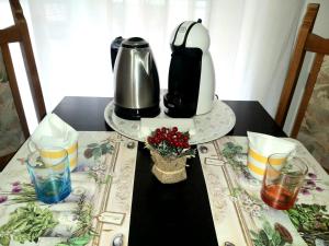 einen Tisch mit Kaffeemaschine und Gläsern darauf in der Unterkunft Amico Del Sole in Rom