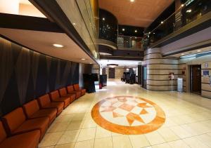 a lobby with orange chairs and a rug on the floor at APA Hotel Osaka Temma in Osaka