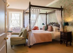 een slaapkamer met een hemelbed en een stoel bij Durn House in Portsoy