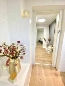um corredor com um vaso de flores sobre uma mesa em 75qm mit eigenem Bad, Küche, Wohn- u Schlafzimmer em Herborn