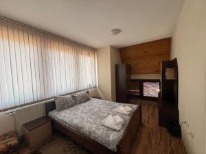 een kleine slaapkamer met een bed en een raam bij Panorama Guest House in Smolyan