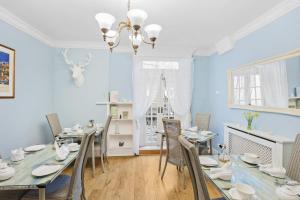 een eetkamer met blauwe muren en een tafel en stoelen bij Kingston House in Torquay