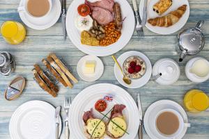 uma mesa com pratos de café da manhã e café em Kingston House em Torquay