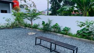 a bench sitting in the middle of a garden at pasaDhamHouse in Parit