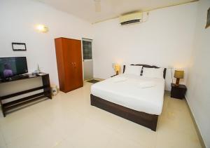 a bedroom with a bed and a flat screen tv at Birdsong Leisure Resort in Tissamaharama