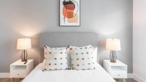 1 dormitorio con 1 cama con 2 mesitas de noche y 2 lámparas en Landing Modern Apartment with Amazing Amenities (ID4314X66), en Charleston