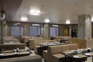 een restaurant met tafels en stoelen in een kamer bij Clarks Collection Somnath in Somnath