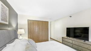 1 dormitorio con 1 cama y TV de pantalla plana en Landing Modern Apartment with Amazing Amenities (ID1017X869), en White Bear Lake
