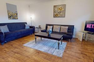 een woonkamer met een blauwe bank en een salontafel bij Stunning 2-Bed Apartment in Grays in Grays Thurrock