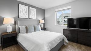 a bedroom with a bed and a flat screen tv at Landing Modern Apartment with Amazing Amenities (ID1779X58) in Vancouver