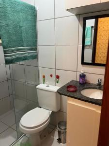 a bathroom with a toilet and a sink and a mirror at APARTAMENTO CONFORTO in São Luís