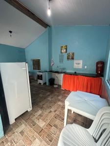a room with a table and a white refrigerator at Casadabiquinha in Pirenópolis