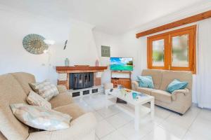 sala de estar con 2 sofás y chimenea en Can Cladera en Playa de Muro