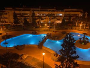 a swimming pool at night with a hotel in the background at Victor Villa Romana in Roquetas de Mar