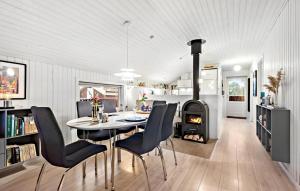 a kitchen and dining room with a table and a fireplace at Nice Home In Blvand With 3 Bedrooms And Wifi in Blåvand