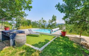 un patio trasero con piscina y césped con silla en Lovely Home In Mercuer With Outdoor Swimming Pool en Mercuer