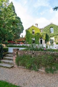 a house covered in green ivy with stairs and flowers at Milsoms in Dedham