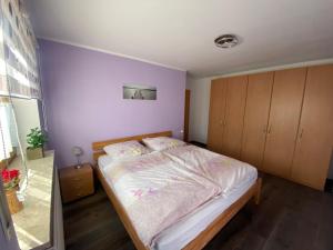 Un dormitorio con una cama grande con paredes moradas. en Kulmblick Kastl, en Kastl