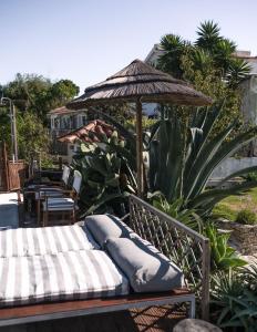 a bench with an umbrella and pillows on it at João Jungle in Açafora