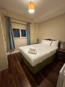 een slaapkamer met een bed met handdoeken erop bij St Bridget's Apartments in Galway
