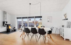 una sala da pranzo con tavolo, sedie e camino di Beautiful Home In Otterup With Sauna a Otterup
