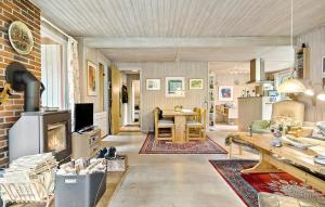 uma sala de estar com uma mesa e uma lareira em 3 Bedroom Lovely Home In Nex em Vester Sømarken
