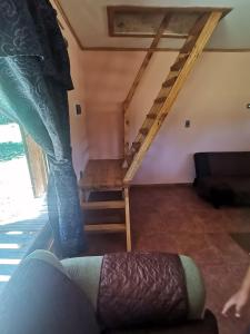 een kamer met een ladder en een bed in een kamer bij Cabaña Bello entorno natural! in Lago Ranco