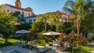 a resort with chairs and umbrellas and a pool at Finca Casabela in Pinos del Valle