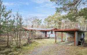 uma casa com um telhado vermelho na floresta em 3 Bedroom Lovely Home In Nex em Vester Sømarken