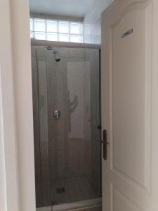 a shower with a glass door in a bathroom at Hostel Ferihegy in Vecsés