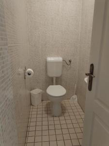 a bathroom with a toilet and a tiled floor at Hostel Ferihegy in Vecsés