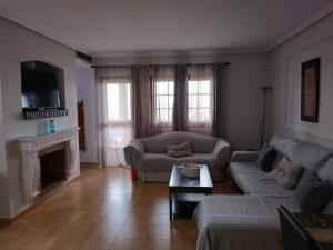 a living room with a couch and a fireplace at Luz de la Bahía II - Bahía Sur - Cádiz in San Fernando