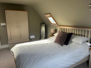 a bedroom with a large white bed with a skylight at The Red Lion Charing Heath in Charing