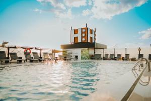 a pool on the roof of a building with chairs at Hotel Málaga Nostrum Airport in Málaga