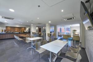 a cafeteria with tables and chairs and a kitchen at City Express by Marriott Reynosa Aeropuerto in Reynosa