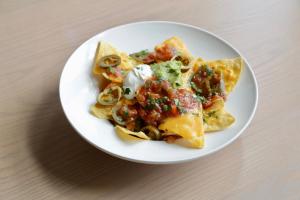 a white plate with nachos on a table at Old Waverley Hotel in Edinburgh