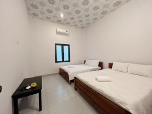 a room with two beds and a window at Huong Giang Bungalow in Phú Quốc