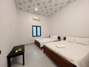una habitación con dos camas y una ventana en Huong Giang Bungalow, en Phu Quoc