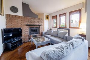 uma sala de estar com um sofá e uma lareira em GetTheKey Villa Cedro em San Lazzaro di Savena