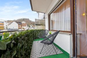 a balcony with two chairs and a window at DD_Homes LahnLiebe - Balkon, Therme, Smart TV in Bad Ems
