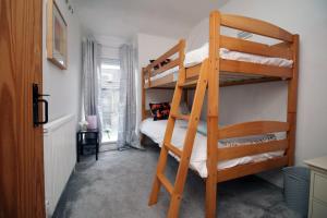 a bedroom with two bunk beds in a room at Rhigos Mountain Cottage by StayStaycations in Treherbert