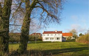 a large white house in a field with a tree at Lovely Home In Slite With Wifi in Slite