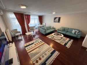un soggiorno con divani verdi e una sala da pranzo di Saygın Apartments a Istanbul