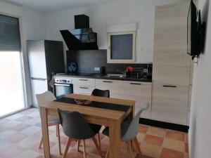a kitchen with a wooden table and chairs in a kitchen at A Casa Assulanata in Santa-Reparata-di-Balagna