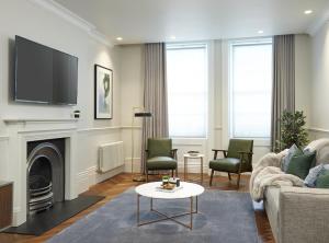 a living room with a fireplace and a tv at Darley House by Viridian Apartments in London