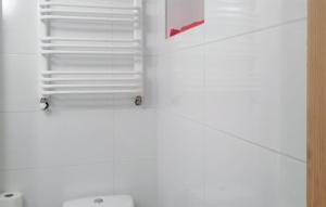 a white refrigerator in a bathroom with a red sign on the wall at 4 Bedroom Gorgeous Home In Kamianna in Kamianna