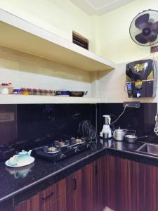 a kitchen counter with a stove and a sink at Sumptuous 1BHk Couple friendly in Lucknow