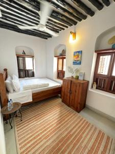 1 dormitorio con 1 cama grande y 1 mesa en Seafarers Loft en Stone Town