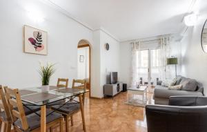 una sala de estar con una mesa y un sofá en Awesome Apartment In Torrevieja, en Torrevieja