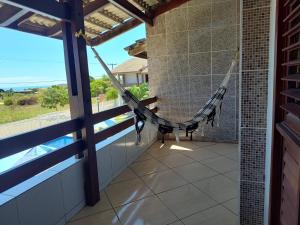 a hammock in a room with a view of the ocean at Chalé na praia de Carapibus in Conde +5 photos